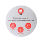 Round badge with nomination URL, and icons: rocket, scales, and people with text.