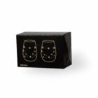 A black cardboard box featuring a gold outline illustration of two stemless wine glasses adorned with star and spark pattern designs. The text ITEM 20124 is visible at the bottom left corner of the box.