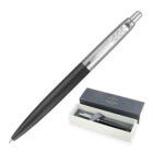A sleek black pen with a silver clip featuring an arrow design, displayed alongside its box. The box is open, showing the pen inside, nestled in a light-colored interior. The brand Parker is visible on the lid of the box.