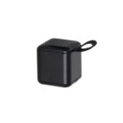A compact black cube-shaped wireless speaker with a small loop handle on one corner, designed for easy portability. The speaker grille is located on the top surface.