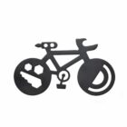 A decorative bicycle design with a unique twist: the front wheel has cut-out shapes of a soccer ball and a shoe, and the back wheel features a large circular letter D. The bicycle is silhouetted in black.
