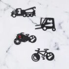 Four black metal multi-tools shaped like vehicles on a white marble surface: a tow truck, forklift, motorcycle, and bicycle. Each tool has notches and cutouts for various functions.