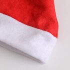 Close-up of a corner of a Santa hat, showing the red fabric with a fluffy white border against a white background.