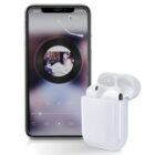 Smartphone displaying a music app with album art on the screen, showing a circular interface. Beside it, a pair of wireless earbuds are placed in an open charging case. The setup is on a white background.