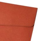 Close-up of a textured brown envelope with a flap. The surface has a subtle line pattern, adding a sophisticated detail to the overall design. The image focuses on the upper part of the envelope.