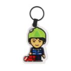 Keychain featuring a cartoon figure wearing a lime green hat and a blue uniform. The character is holding a red object and has a friendly expression. The keychain ring is black.