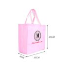 A pink reusable shopping bag with a circular logo featuring the letter M and text below it. It measures 33 cm wide, 25 cm tall, and 6 cm deep. The bag has two handles for carrying.