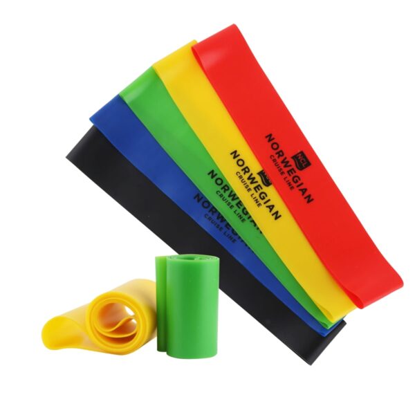 Five exercise resistance bands in varying colors (black, blue, green, yellow, red) are laid flat, displaying Norwegian Cruise Line text. Two additional bands, yellow and green, are rolled up in front of them.
