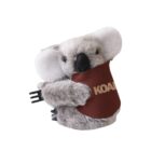 Stuffed koala toy holding a small brown sign with KOALA written on it. The toy is fluffy with light gray fur and large white ears, sitting upright with a cute expression.