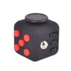 A black fidget cube with red buttons, a metallic sphere, and wheel-like features.