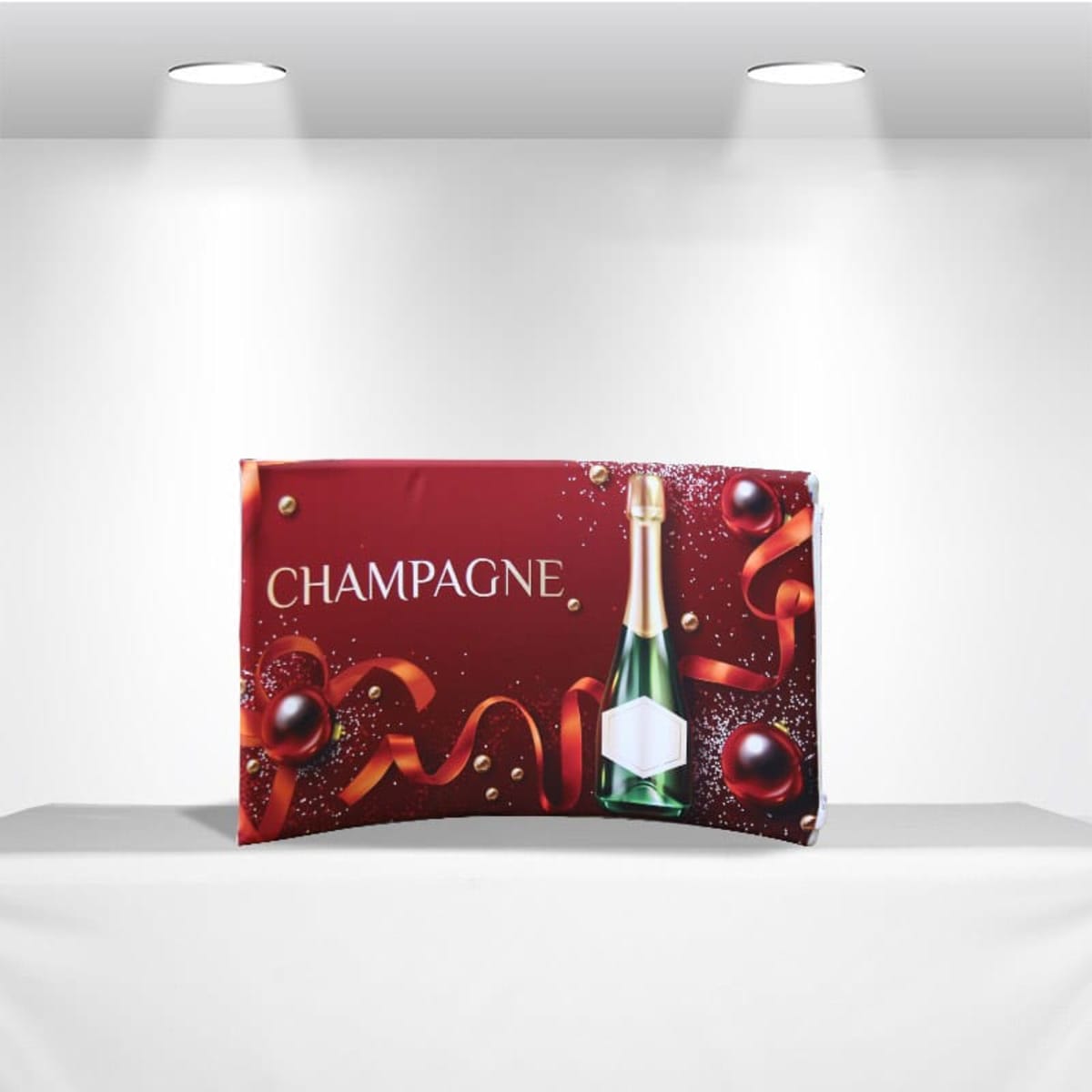 A decorative red gift box featuring the word Champagne in white text. The design includes a bottle of champagne, red ribbons, and ornaments. The box is displayed on a white surface under two spotlights.