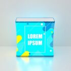 A blue box with abstract yellow and white geometric patterns. The text Lorem Ipsum is centered in white on the front. The background is a gradient of light grey to white, casting a slight shadow from the box.