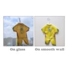 Two panels show a small, yellow outfit with blue trim and a Ukraine map design, hanging on a hook. Left: on glass with a cityscape background. Right: on a smooth wall. Labels read On glass and On smooth wall.