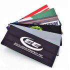 A set of colorful, branded headbands are fanned out. The top headband is black with EXCLUSIVE ENERGY, INC in white text alongside a stylized EE logo. Other headbands feature different colors and designs.