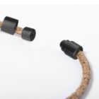 Close-up of a brown, textured cable with black cylindrical connectors at both ends against a white background.