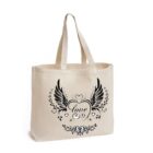 A beige tote bag with handles features a black design of a heart with wings and the word love in cursive inside. Decorative swirls and floral elements surround the heart.