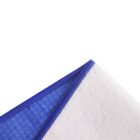 Close-up of a fabric corner folded over. One side is a textured blue material with a honeycomb pattern, and the other side is white. The edge is neatly stitched, and the background is white.