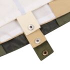 Close-up of a fabric item with overlapping beige and green flaps, each featuring metal snap buttons. The top portion has a white strip with an elastic band, suggesting a fastener or adjustable component.