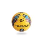 A yellow and black soccer ball featuring a digital pixel pattern with red, blue, and purple accents. The text TELESALE and TS logos are visible on its surface. The ball appears to be floating with a slight shadow below it.