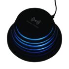 Black circular wireless charger with layered design, emitting blue LED lights between layers. A cable extends from the top.