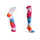 Colorful knee-high socks featuring a playful design with splashes of orange, pink, and blue. One sock is positioned upright, showing the design fully, while the other is bent at the knee. The word MAGIC is visible on one sock.