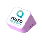 A pink, wedge-shaped device with the aura property sunshine coast logo on top. The logo features a stylized letter A in blue and green. The device has small buttons on the side.