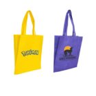 Two tote bags: a yellow one with a Pokémon logo and a purple one with a Greyhound logo featuring a dog and sun design. Both bags have long handles and are displayed side by side on a white background.