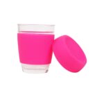 A transparent glass cup with a pink silicone sleeve, accompanied by an additional pink silicone lid placed on its side. The sleeve and lid are bright and vibrant, emphasizing the cups modern design.