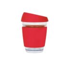 A transparent reusable cup with a red silicone sleeve and lid. The cup is designed for hot beverages and has a modern, sleek appearance.