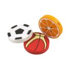 Three round erasers: one resembles a black-and-white soccer ball, another a basketball with orange and red, and the third an orange slice with yellow and orange segments. They are arranged in a casual cluster.