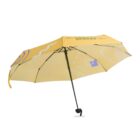 A yellow umbrella with abstract blue, white, and purple geometric patterns, featuring a black handle and frame, is open and visible against a white background.
