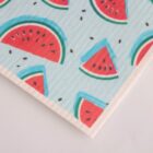 Patterned paper towel featuring illustrations of watermelon slices with red flesh, black seeds, and green rind on a light blue background. The design is playful and colorful.