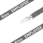 Grey lanyard with the words EMPLOYEE and TERRITORY GENERATION printed in white. It features a metal hook clasp for attaching ID cards or badges. The background is white, highlighting the lanyards design and text.