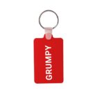 A red keychain with a rectangular tag that has the word GRUMPY written vertically in white letters.