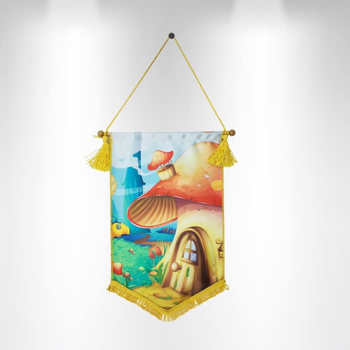 Colorful wall hanging depicting a whimsical scene with a large mushroom-shaped house in a vibrant landscape. The banner is adorned with yellow fringe and tassels, hanging on a light background.