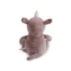 A plush brown unicorn is sitting with its back facing the viewer. It has a white horn, round ears, and a short tail. A fabric tag is visible on its side.