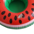 Close-up of an inflatable pool float shaped like a watermelon slice. The float is red with black seeds on top and green around the sides, featuring a clear valve for inflation.