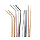 A collection of reusable metal straws laid out in a row. The straws vary in color, including gold, copper, silver, and green. Some straws are straight while others are bent at an angle.