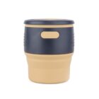 A beige and black cylindrical cup with a lid. The cup has a minimalist design, featuring a textured surface near the top for grip and a smooth lower section.