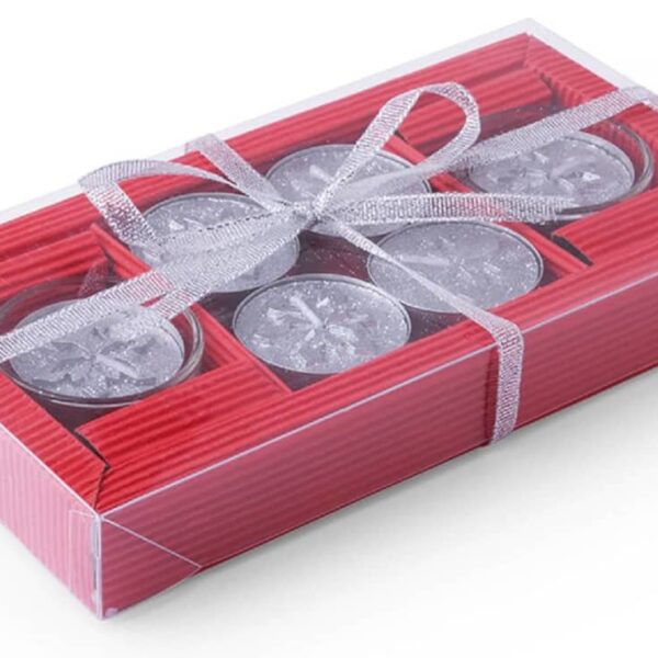 A transparent box containing six silver tea light candles tied with a silver ribbon. The candles are arranged in two rows on a red textured base.