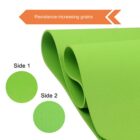 Close-up of a rolled green exercise mat showing two sides with different textures. An arrow at the top reads Resistance-increasing grains. The side 1 circle shows a smooth texture, and the side 2 circle shows a textured pattern.