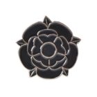 A black and silver enamel lapel pin shaped like a stylized rose with layered petals, outlined in silver.
