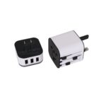 Dual-view of a universal travel adapter: one part showing three USB ports, and the other part displaying different plug types suitable for various countries. The adapter is primarily black and white.