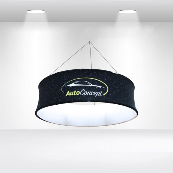 A circular hanging ceiling light fixture with a black shade featuring a car logo and the text AutoConcept in white and yellow. The fixture is suspended by cables, illuminated by ceiling lights in a minimalist white room.