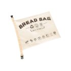 A beige reusable bread bag with BREAD BAG and REUSABLE printed on it. Icons below show bread-related images and recycling symbols. The bag has a buckle closure on one side.