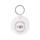 A round white keychain with the logo CLEVE RURAL TRADERS in black. The initials C R are prominently displayed in the center, encircled by wheat-like designs.