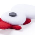 A plush toy shaped like a cloud with a magnet on top, featuring white body and red accents for the feet and tail. The toy lies flat on a white background.