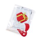 A clear plastic bag contains a paper cutout of a red and yellow gift box and two red heart-shaped sticks, each with a white snowflake and the words Merry Christmas.