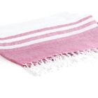 A folded white and pink towel with fringed edges. The towel features two white horizontal stripes on a pink background.