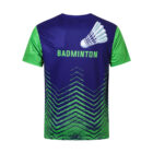 A short-sleeved sports shirt with a blue body and green sleeves. The back features a shuttlecock graphic and the word BADMINTON in bold, above an abstract green zigzag pattern on the lower half.